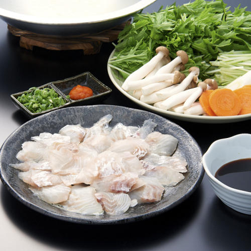 テーブルにしゃぶしゃぶ用にスライスした鯛、カットした野菜、薬味が並んでいる。